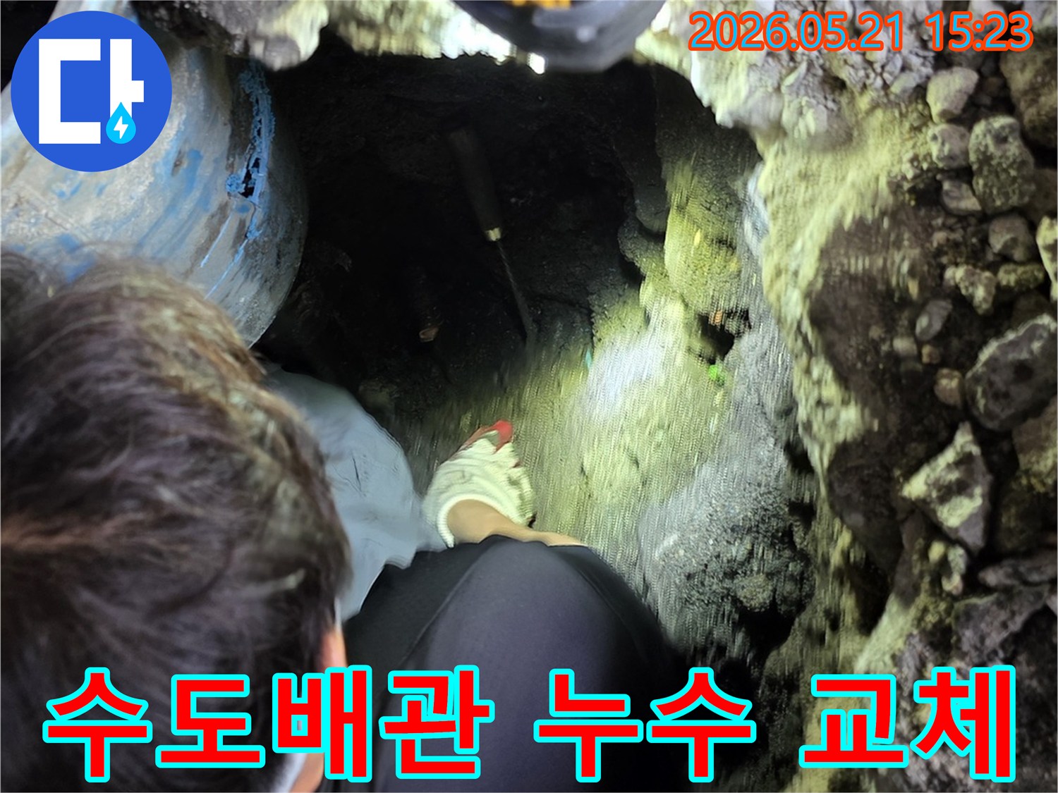 전문 엔지니어가-어두운 굴착 현장에서-손전등을 비추며-오래된 수도배관의 누수 지점을-정확히 파악하여-완벽한 교체를 준비하는 모습입니다.