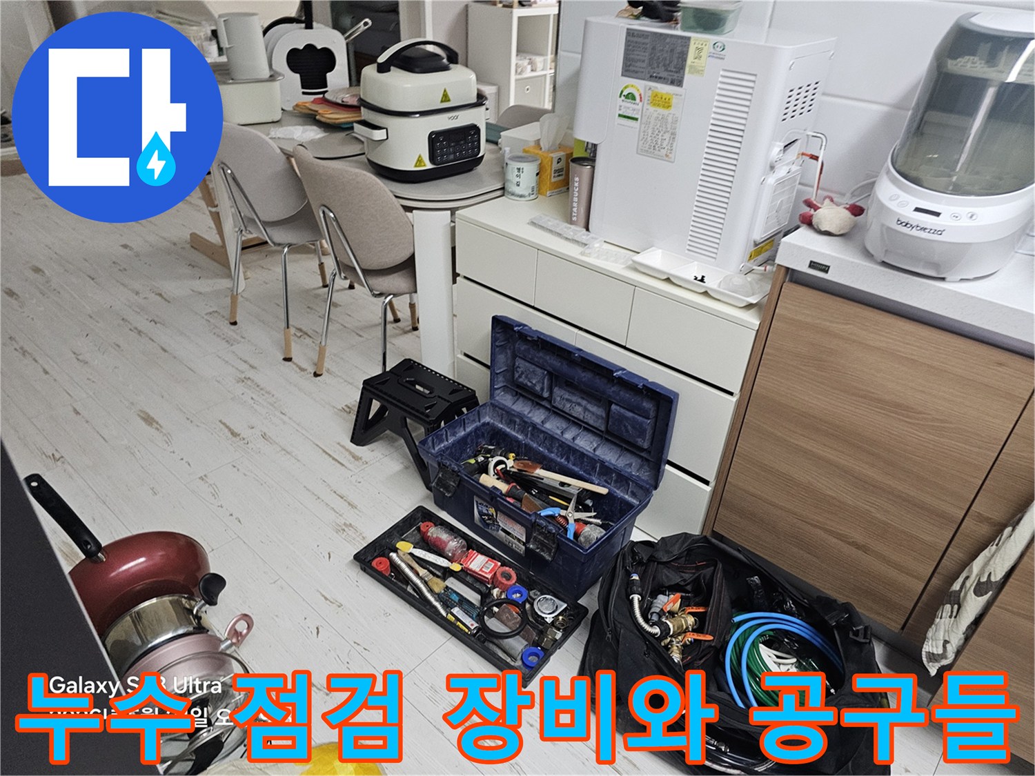 싱크대 하부장 정리 후 배치된 누수 탐지용 수공구와 전문 장비들