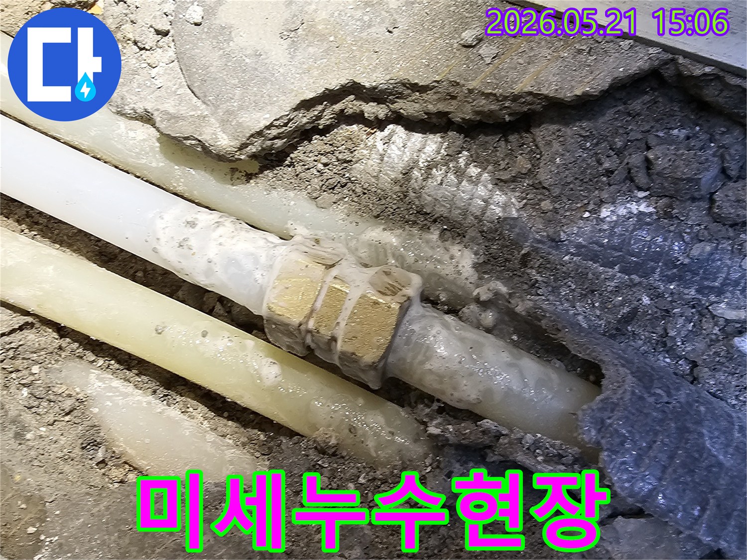 콘크리트 바닥 아래-오래된 배관의 연결 부위에서-미세하게 물이 새어 나와-주변을 적시고 있는-누수 현장의 모습입니다