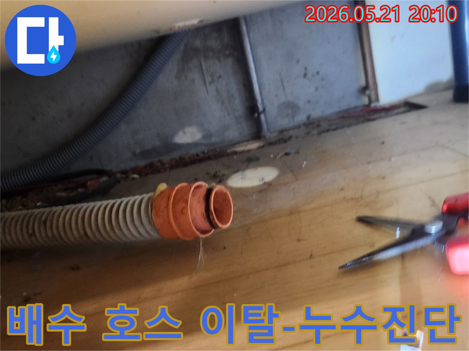 누수 현장에서-배수 호스가-연결 부위에서-분리되어 있는-상태를 촬영한 사진