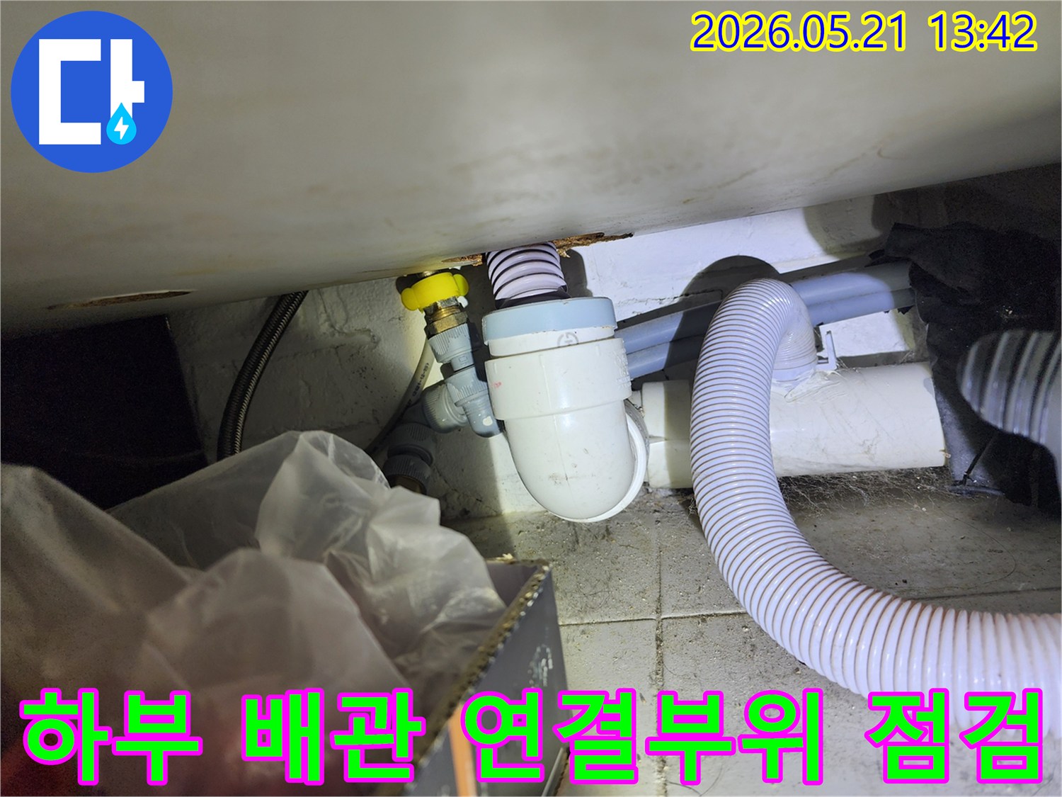 아파트 하부에서 발견된 누수 지점을 확인하기 위해-배관 연결 부위를 정밀하게 점검하는 모습입니다.