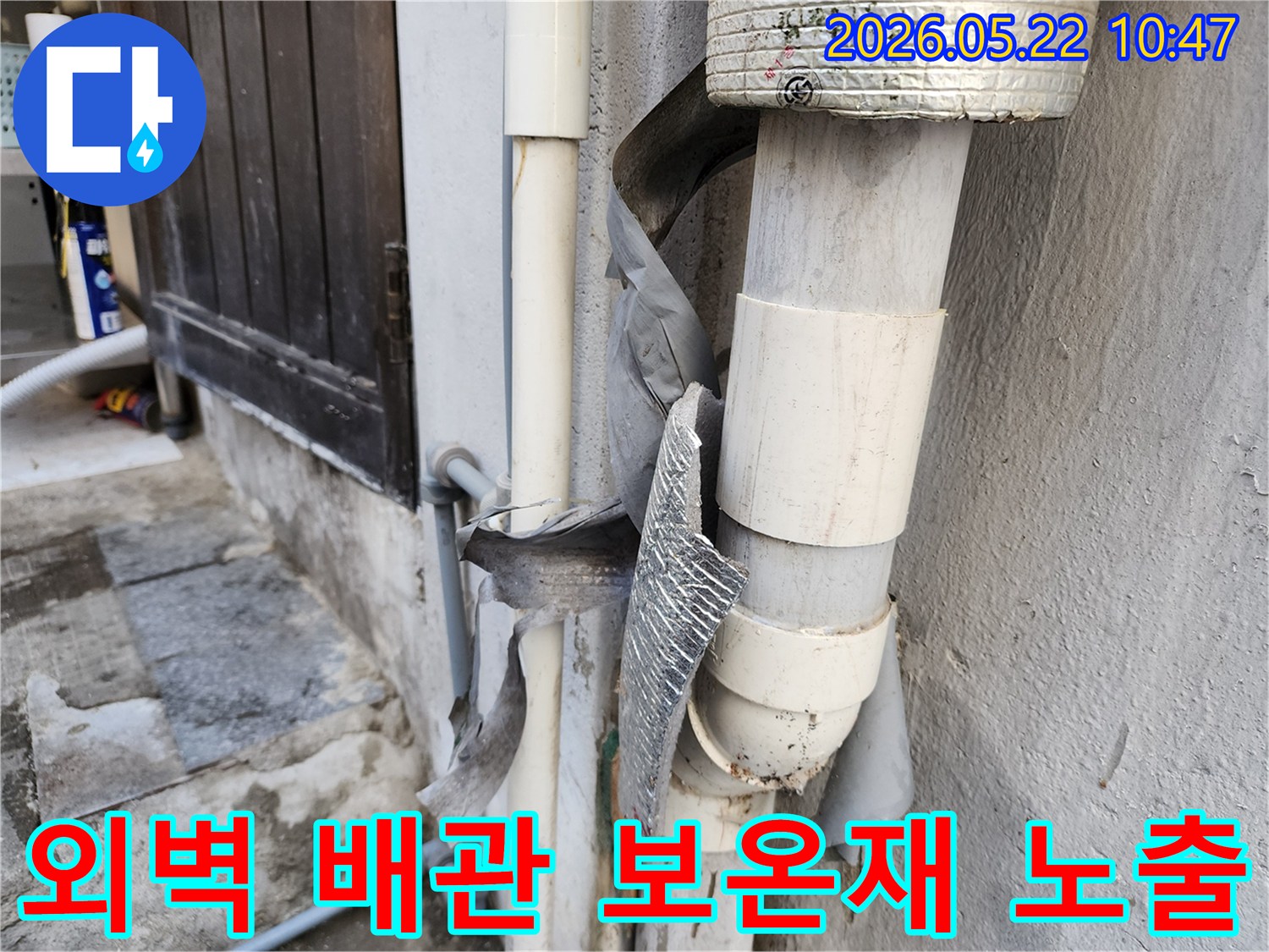건물 외벽 배관의 보온재가-자외선과 외부 환경에 노출되어-심하게 손상된 모습입니다.