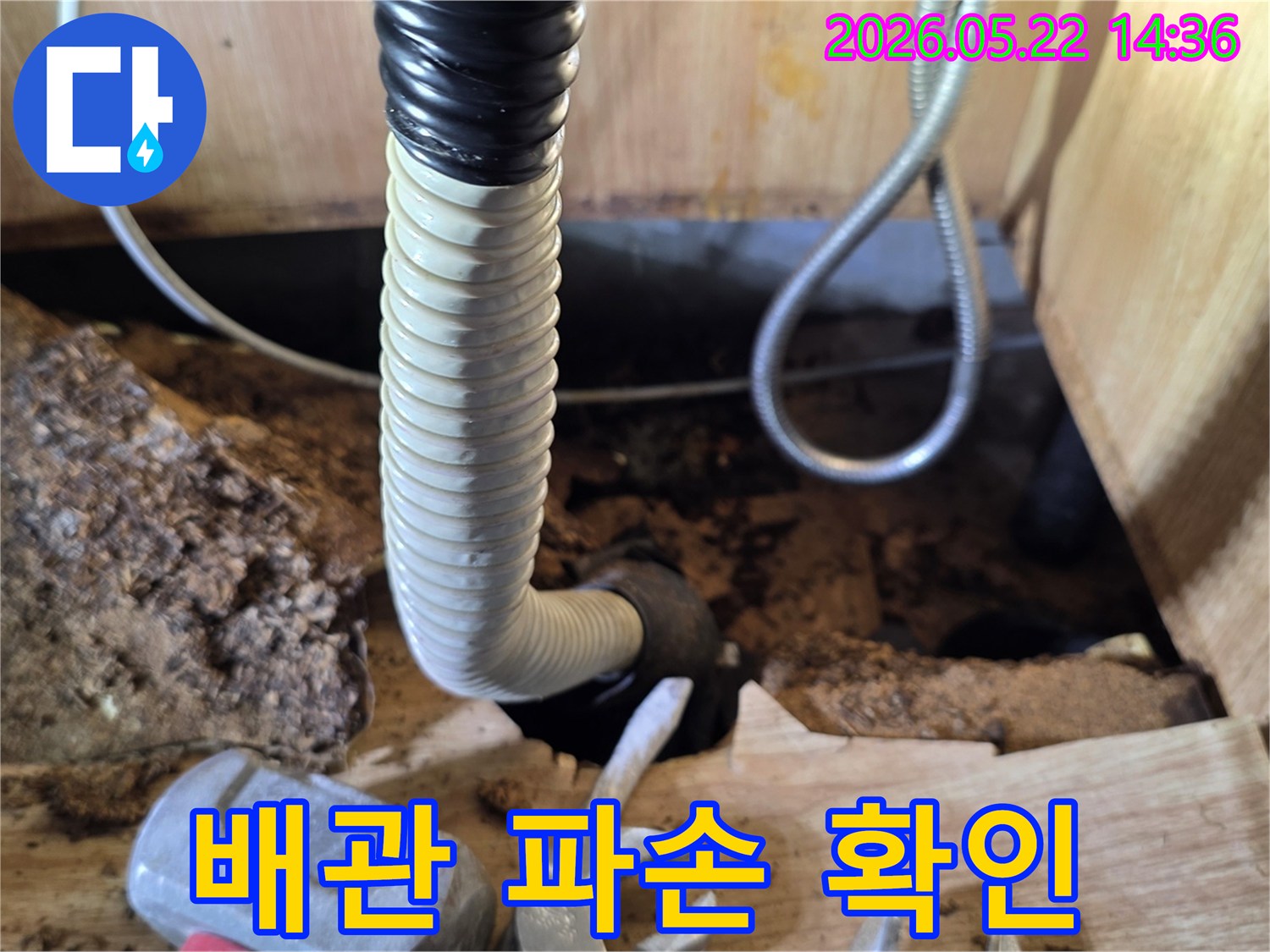 골판지 파이프와 공구가 보이는 클로즈업 사진으로-물 손상 수리가 진행 중임을 암시합니다.