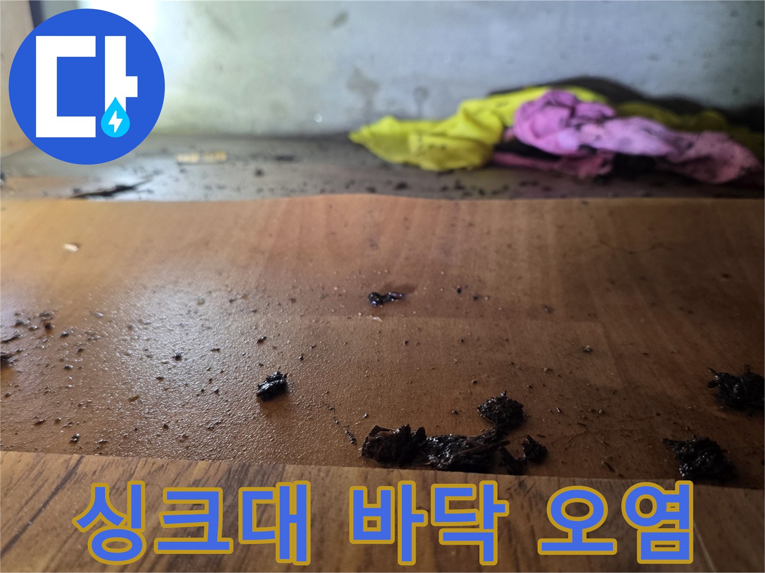 광명 현장-싱크대 하부장 바닥의 나무판이 물샘으로 인해 변색되고 부식된 모습