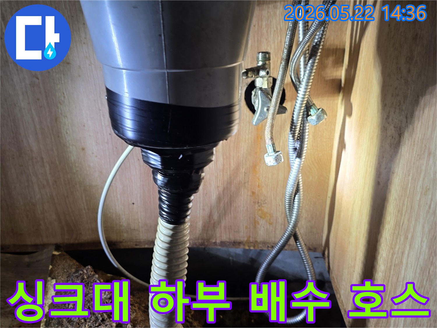 싱크대-하부에-설치된-회색-배수관과-연결된-골진-배수-호스의-모습입니다