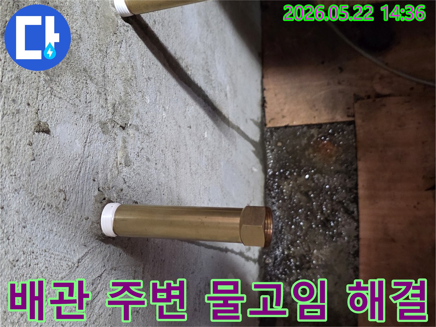 천장에서 내려온 금속 배관 주위로 물이 고여있는-누수 현장을 확인하고 해결하는 과정을 보여주는 이미지입니다.