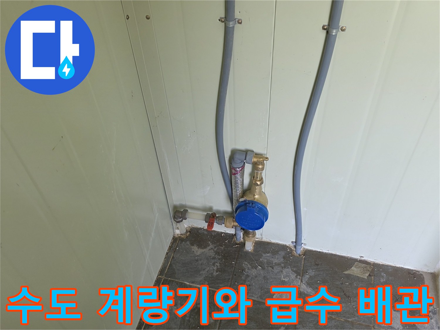 벽면에 설치된 회색 관과 파란색 수도 계량기 연결 상태