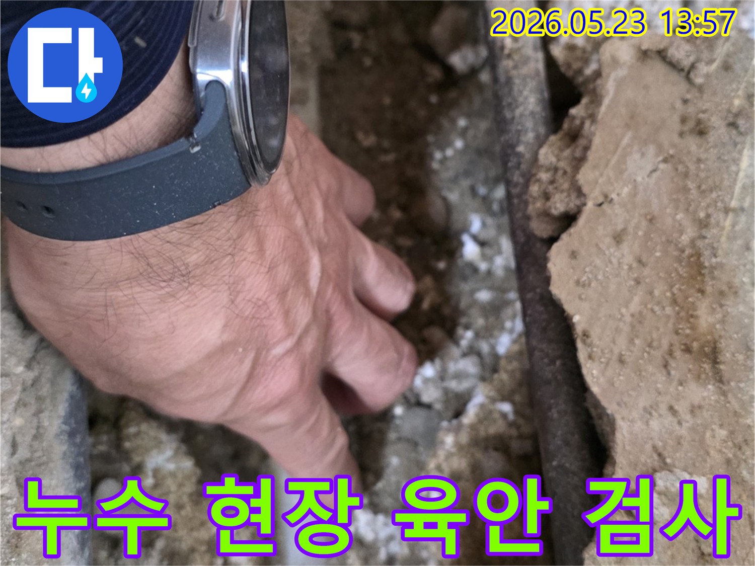 누수 전문가가-손으로 직접-배관 주변의-젖은 흙과-벽면을-세심하게-살펴보는 중입니다
