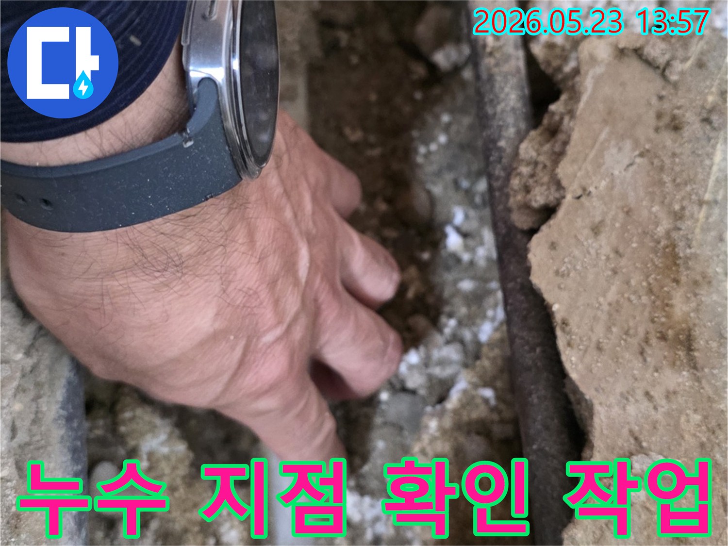 누수 전문가가-손으로 직접-배관 주변의-젖은 흙과-벽면을-세심하게-살펴보는 중입니다