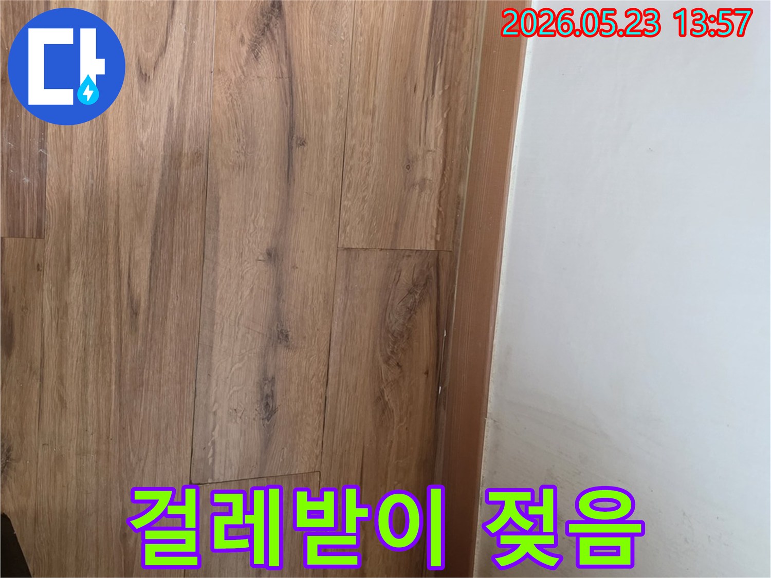 벽면과-마루-사이의-걸레받이가-누수로-인해-젖어-변색된-모습을-촬영한-사진입니다.