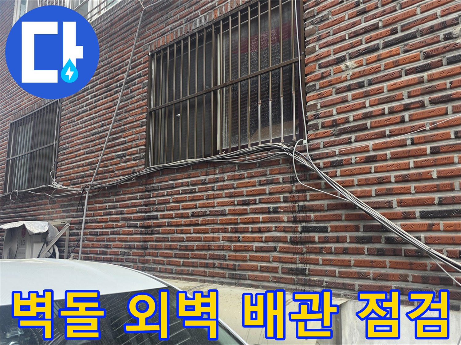 붉은 벽돌로 마감된 건물 외벽과 창문 아래 설치된 노출 배관