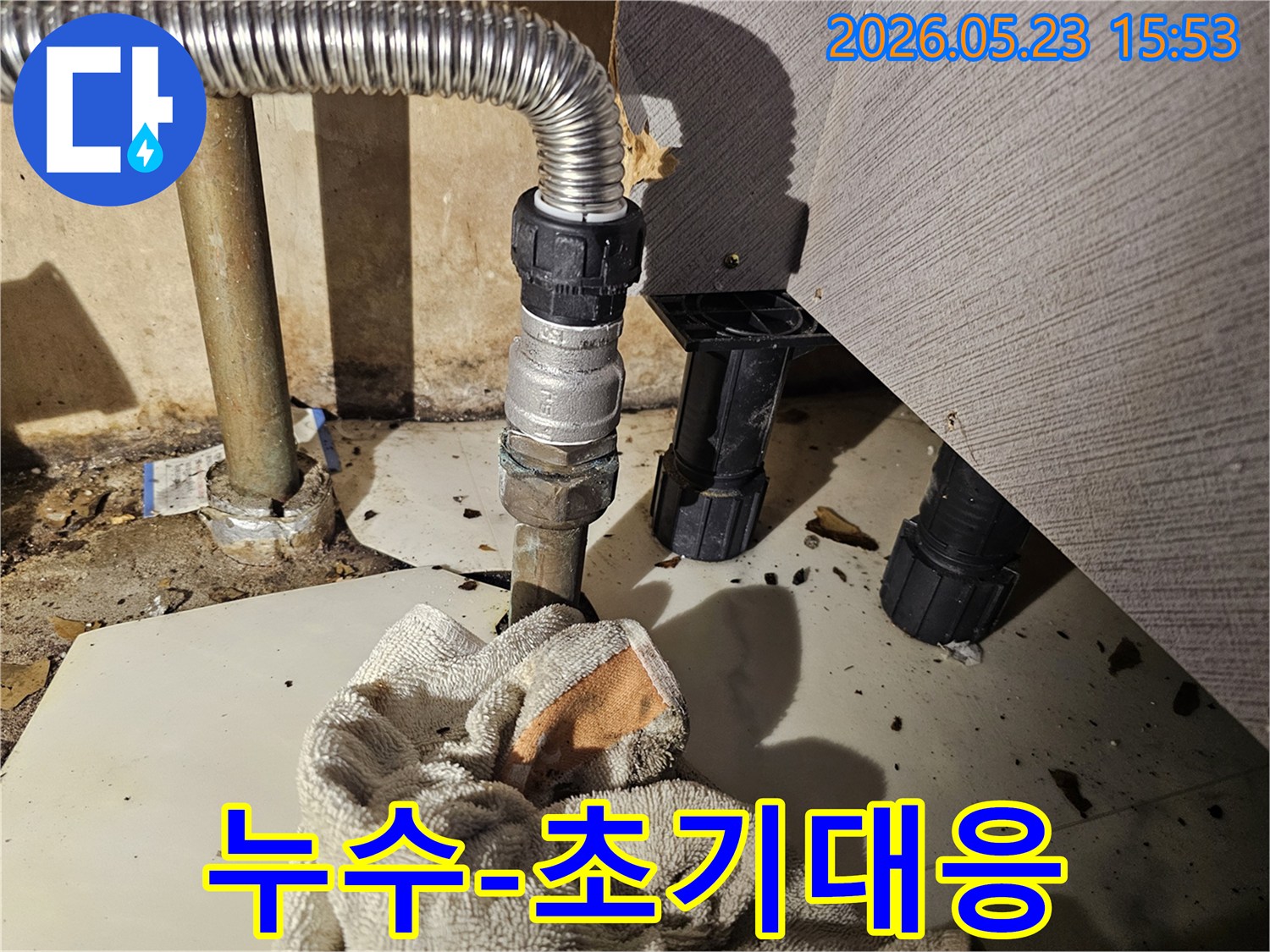 배관 연결부에서 물이 새어-바닥에 젖은 수건이 놓인-누수 초기 대응 현장