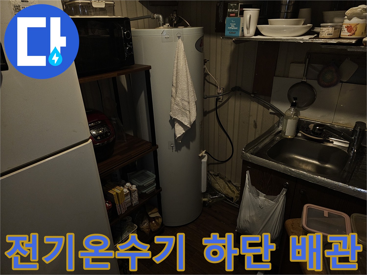 전기온수기와 싱크대 선반 사이의 배관 연결 상태를 보여줍니다.