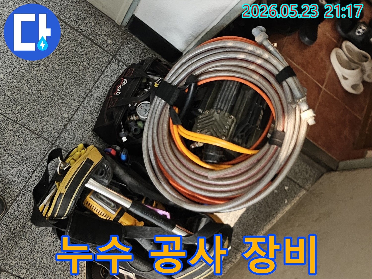 누수 공사를 시작하기 전-엔지니어가 현관에서-탐지 장비와 공구 가방을-정리하고 있는 모습입니다