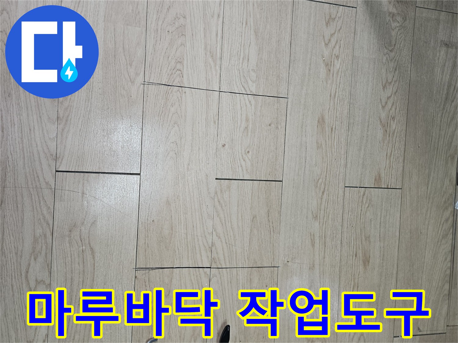나무 무늬 마루 위에 놓인 백색 실리콘과 실리콘 건