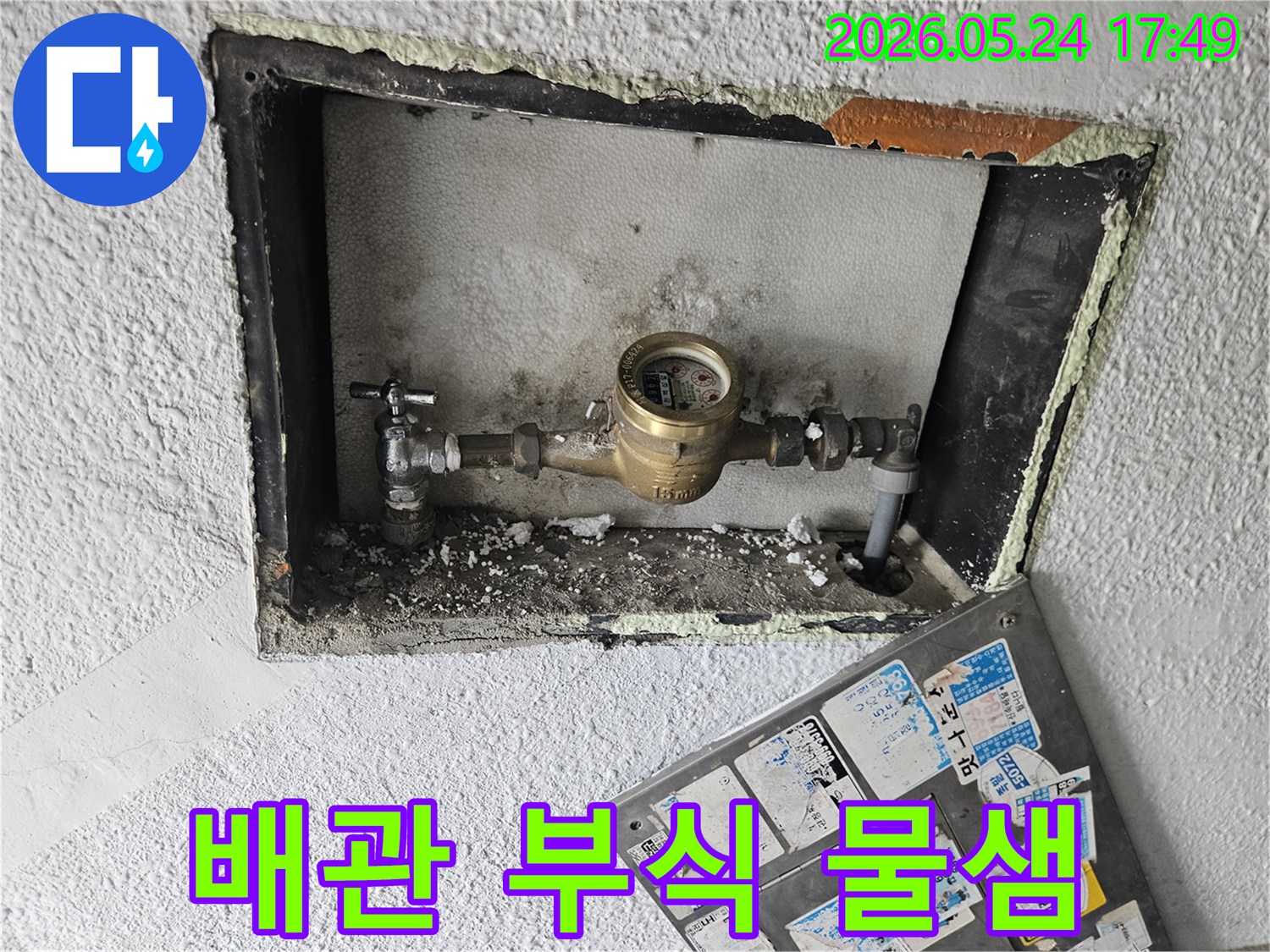 부식된 수도 계량기 주변 배관에서-물이 새어 나오는 흔적을-선명하게 보여주는 이미지입니다.