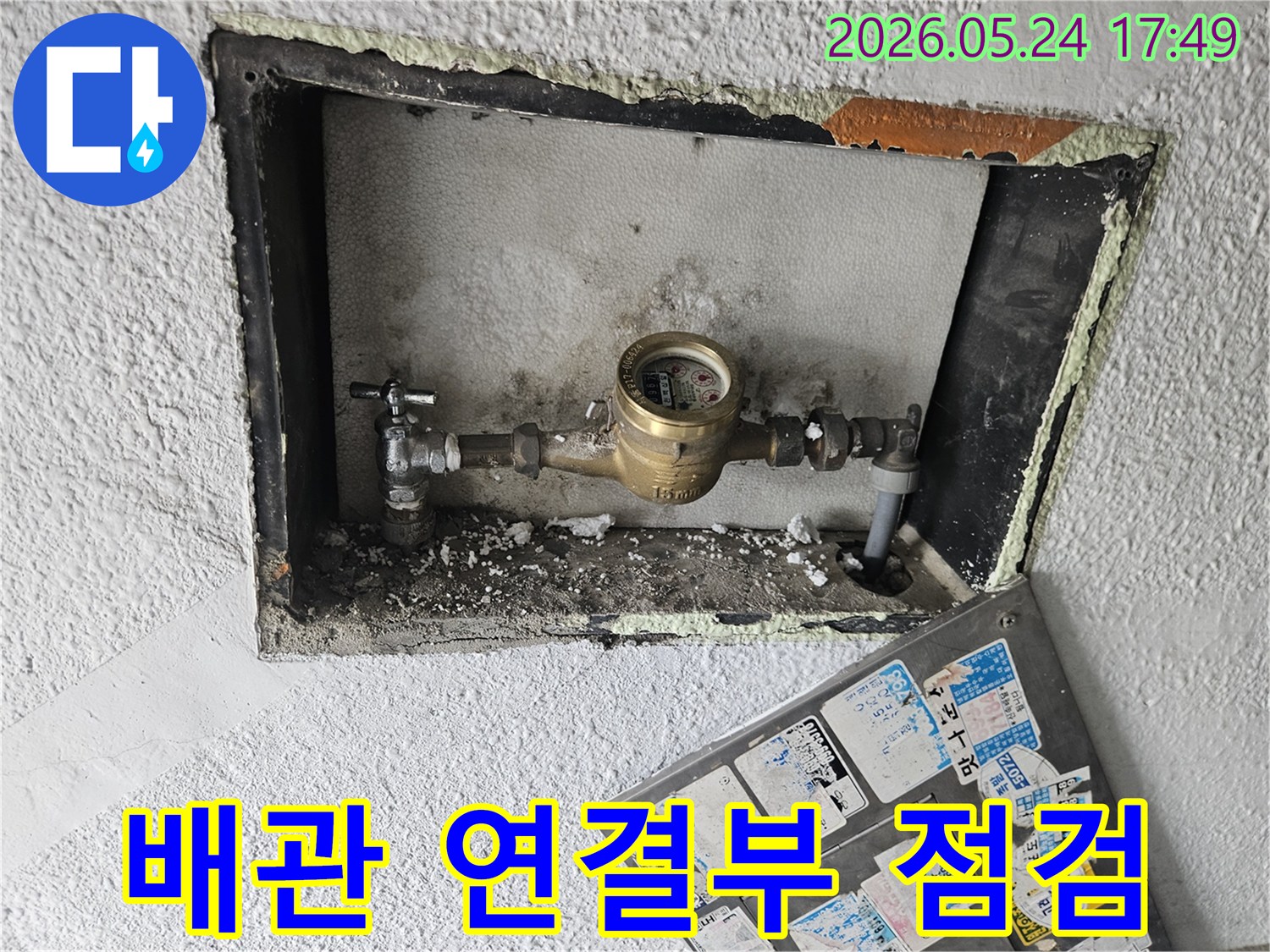 상가 건물 수도 계량기의-배관 연결 부위에서-누수 흔적을 확인하는-전문가의 모습입니다.