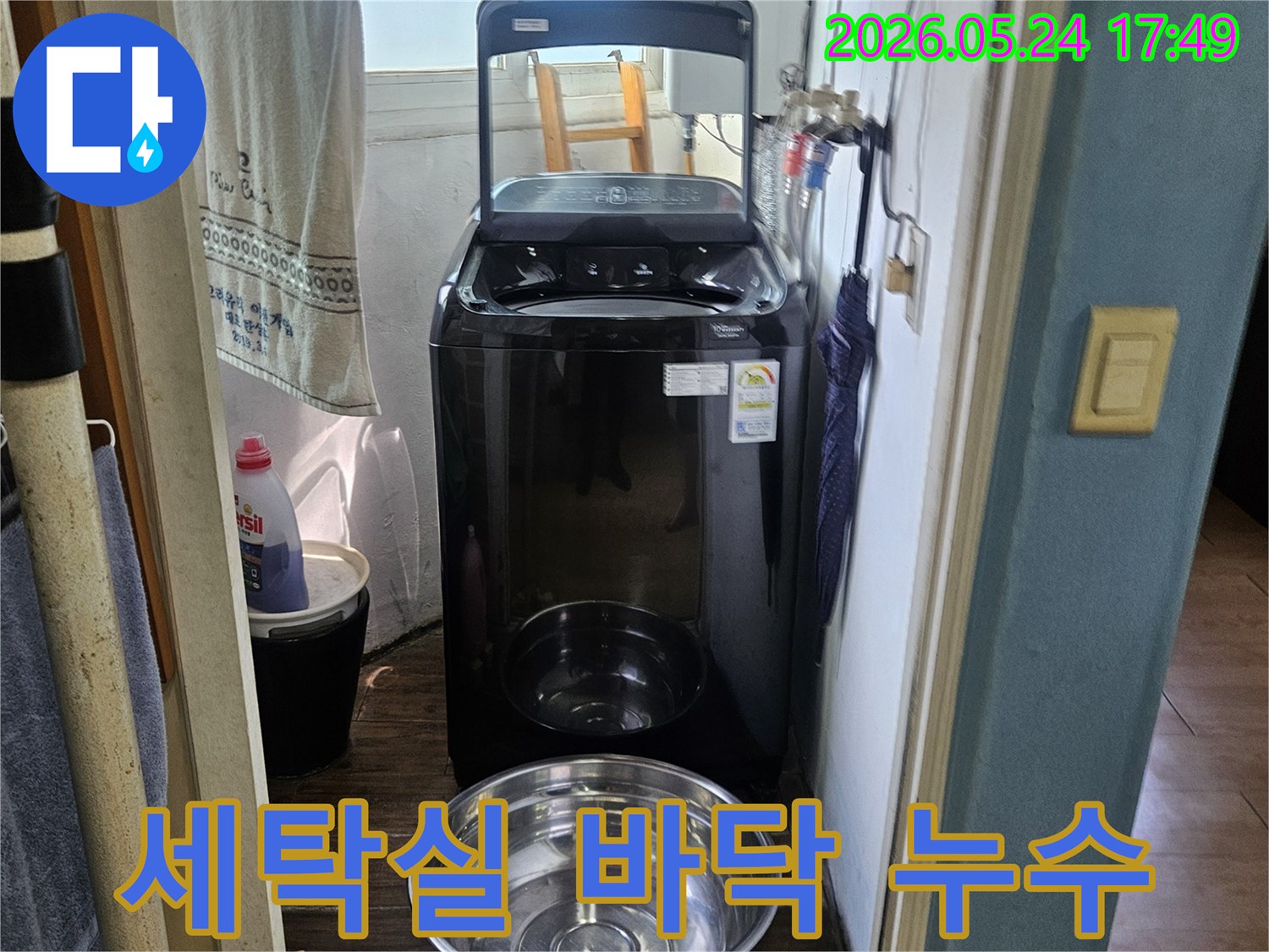 세탁기 옆에-놓인 양동이가-물이 새는-현장을 임시 조치한-사진
