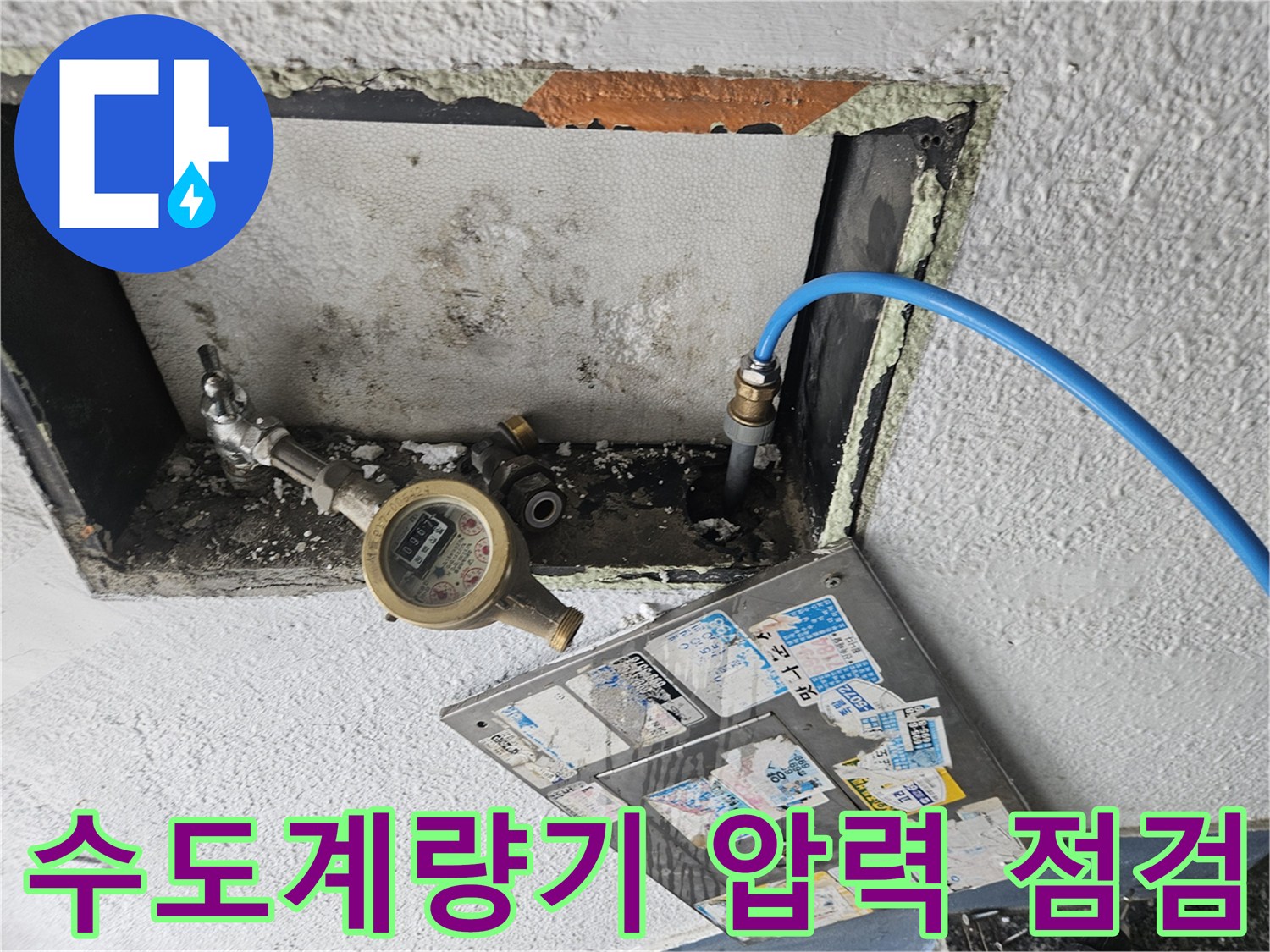 수도 계량기와 파란색 호스가 연결된 배관 점검 모습입니다.