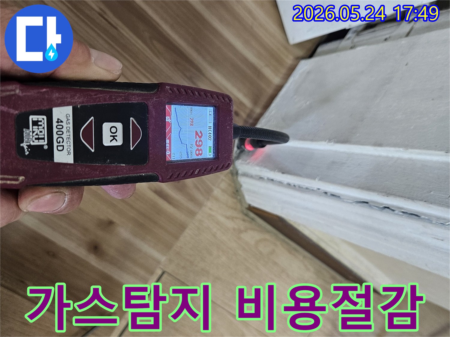 숙련된 누수 엔지니어가 가스 탐지기를 사용하여 벽면 하단에서 누수 반응을 면밀히 확인하고 있습니다.