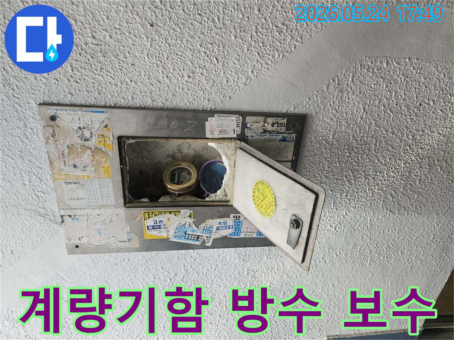 오래된 수도계량기함이 열려있고-내부의 방수층이 손상되어-보수 작업이 필요한 현장입니다.
