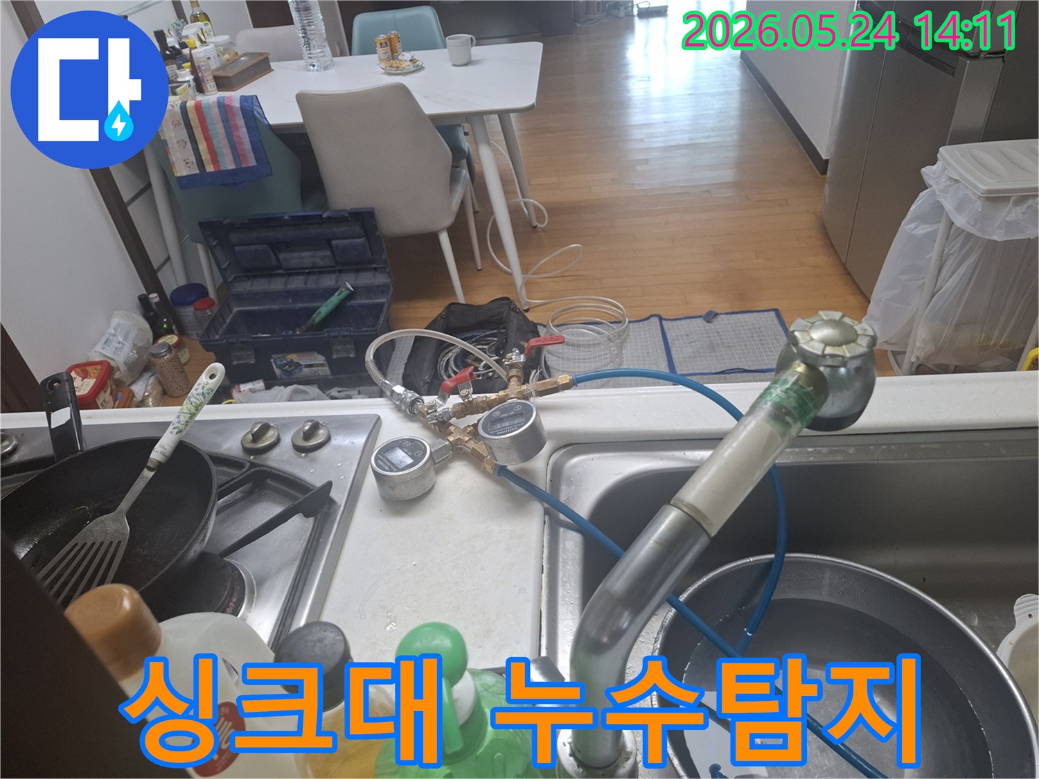 싱크대에서 누수 탐지 장비를 연결하여 배관 상태를-정밀하게-점검하는-모습입니다