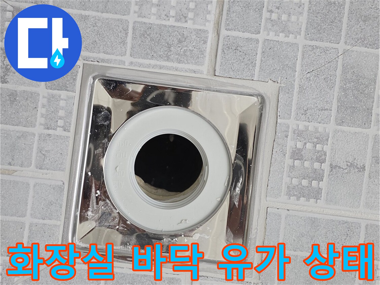 금속 마감재로 된 욕실 배수구와 주변 타일 배열