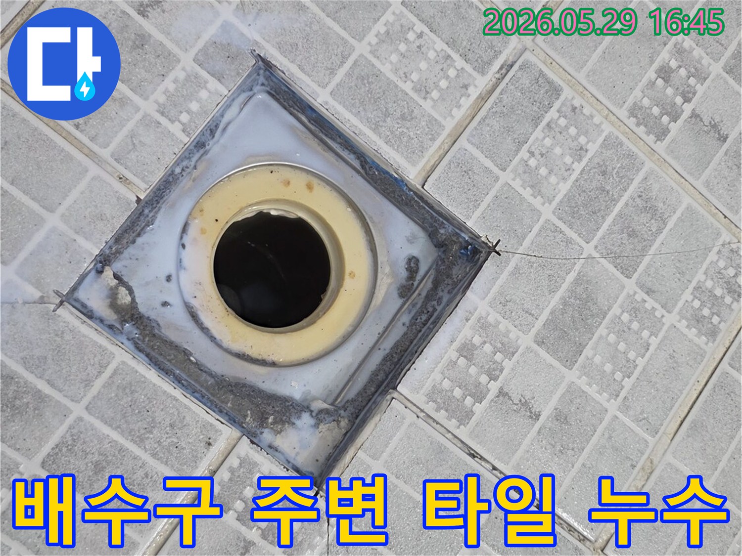 배수구 주변 타일이 깨지고-틈새가 벌어져 누수가 발생한 현장을 보여주는 이미지