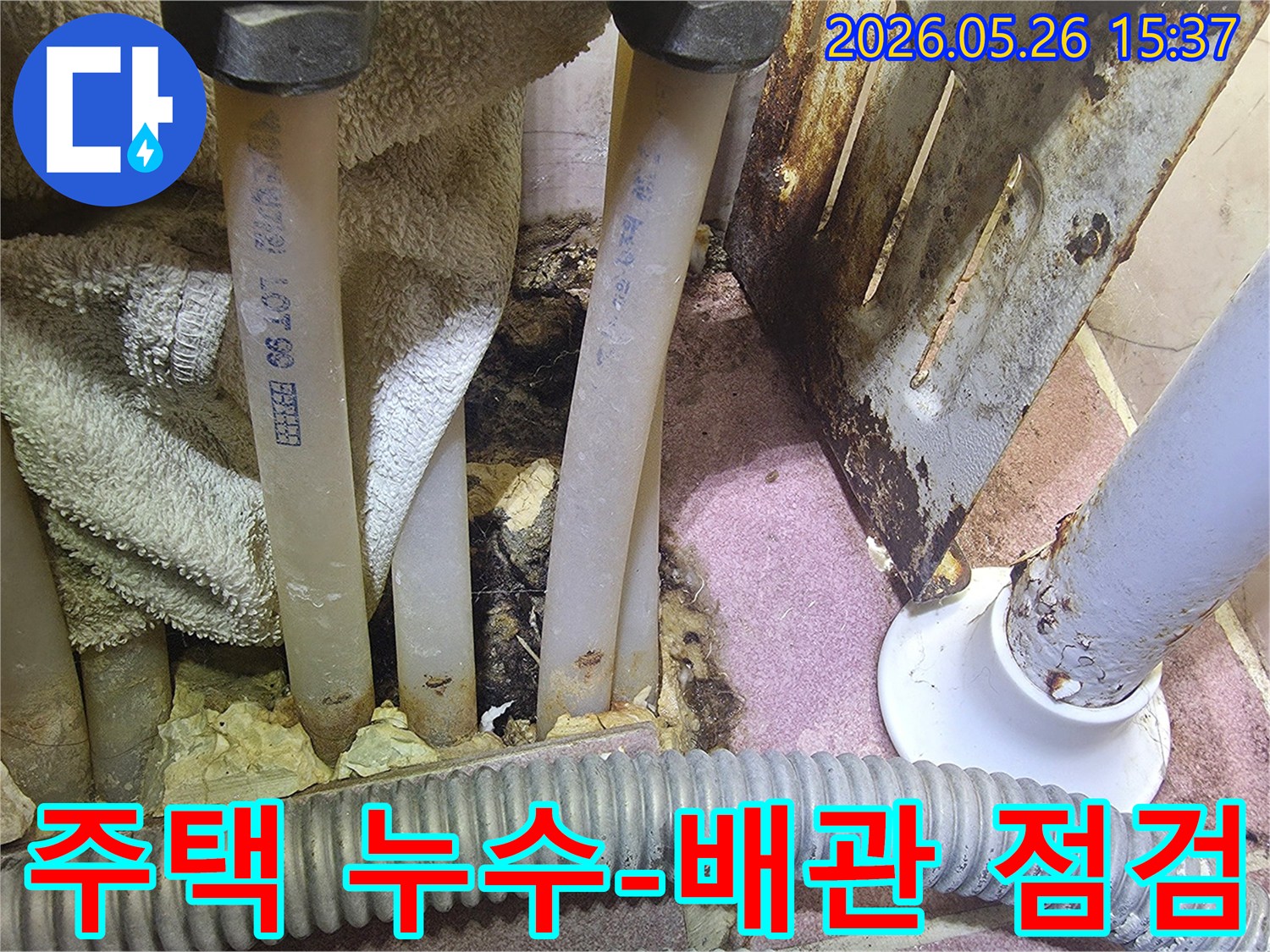 이 사진은 주택 내부 배관 주변에 물이 새어 생긴 부식과 오염의 흔적을 보여줍니다.