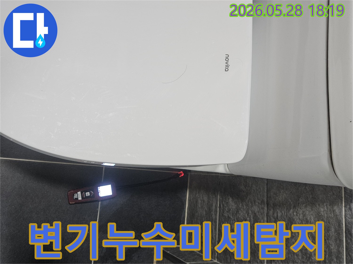 화장실 변기 옆-바닥 타일 틈새에서-누수 탐지 장비가-빨간 불빛으로-누수 지점을 표시하고 있습니다.