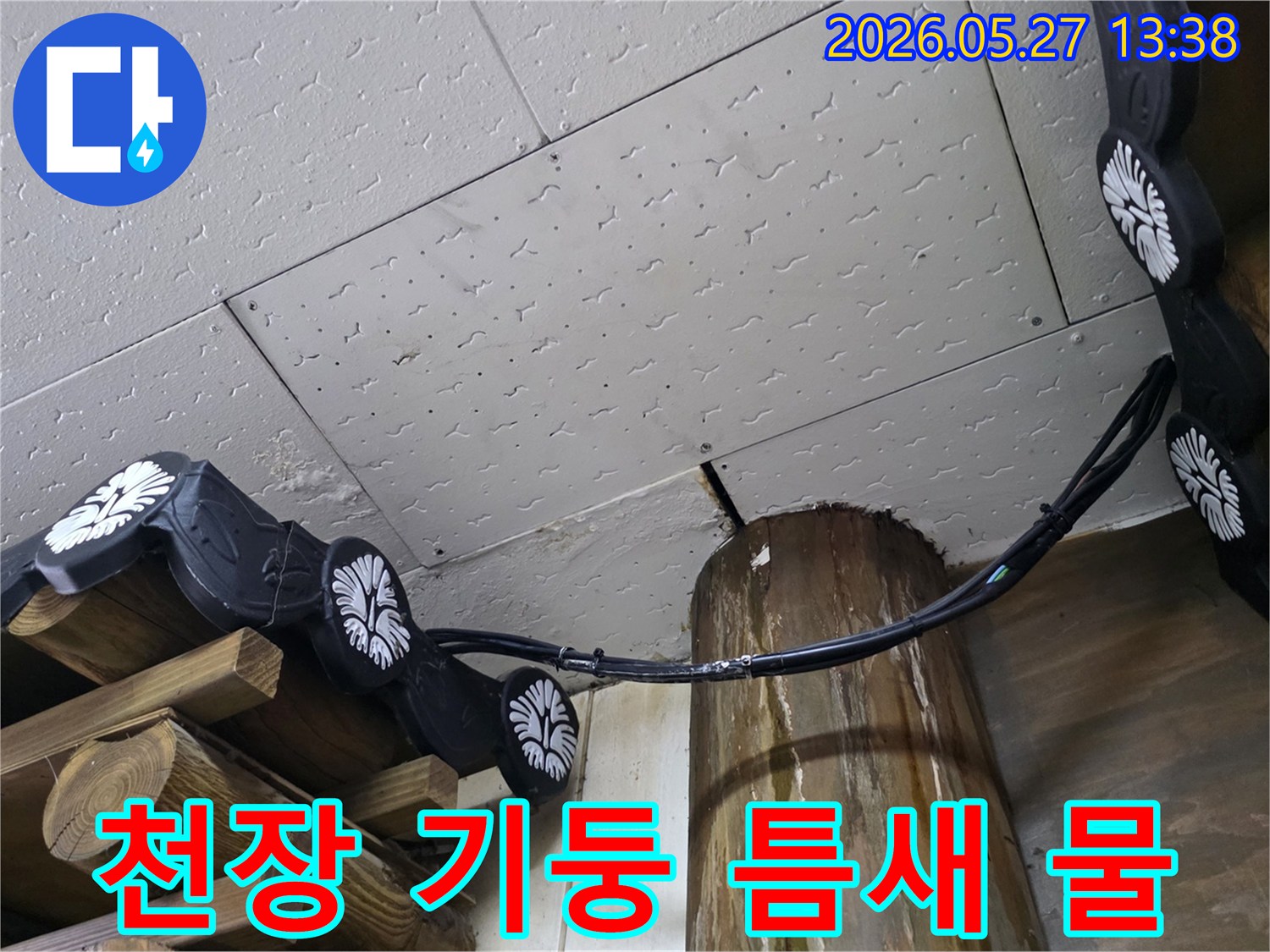 천장-마감재와-목재-기둥-사이의-틈새에서-물이-새는-누수-현장을-정밀하게-점검하는-모습