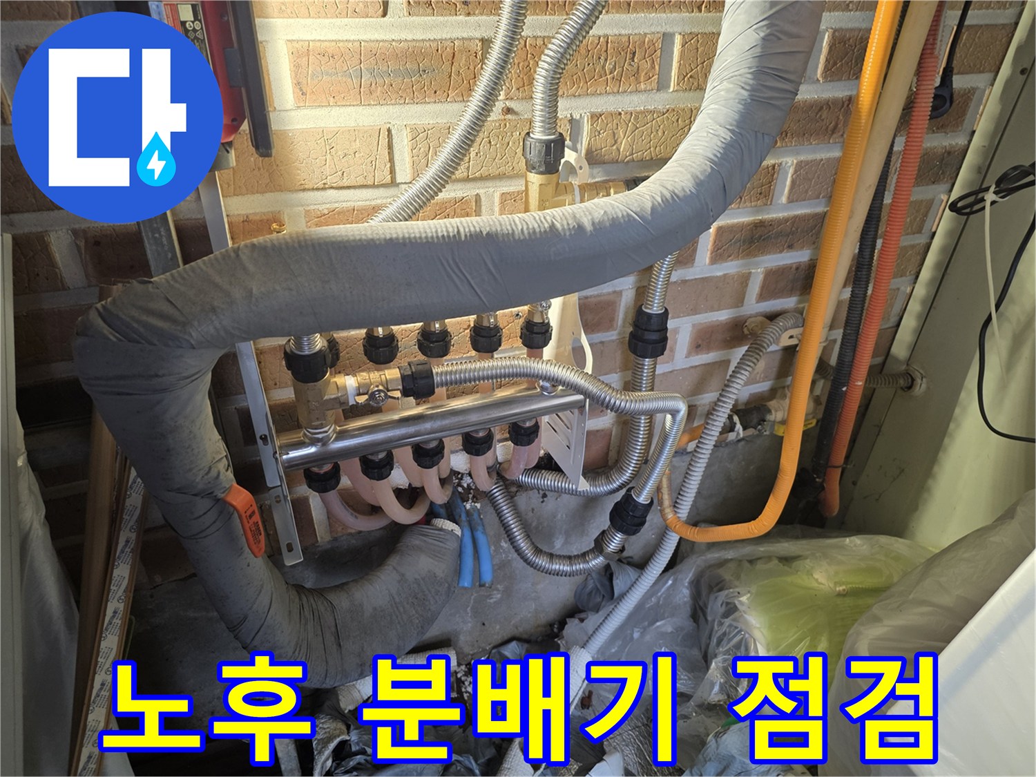 금속 재질의 분배기와 은색 보온재로 감싸진 배관들입니다.