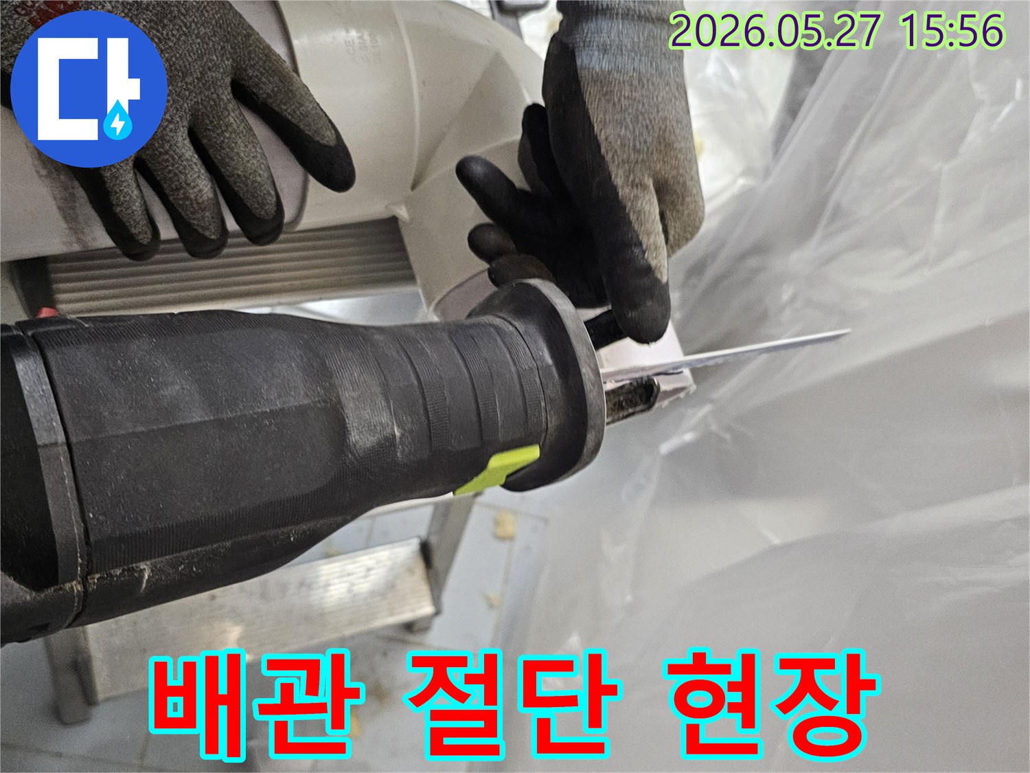 숙련된-작업자가-안전장갑을-착용하고-전기톱으로-PVC-배관을-정밀하게-절단하고-있습니다