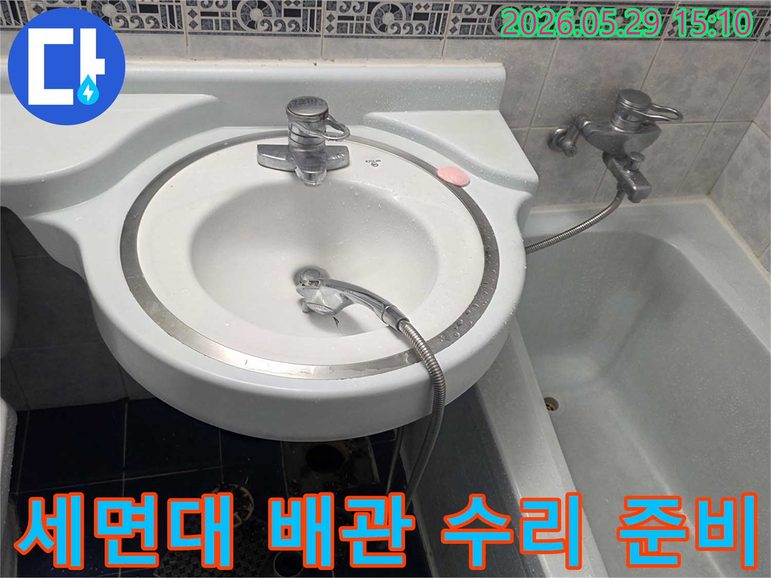 욕실 세면대 아래에서 물이 떨어지는 증상으로-인한 누수 현장을-전문가가 수리 준비하는 모습입니다.
