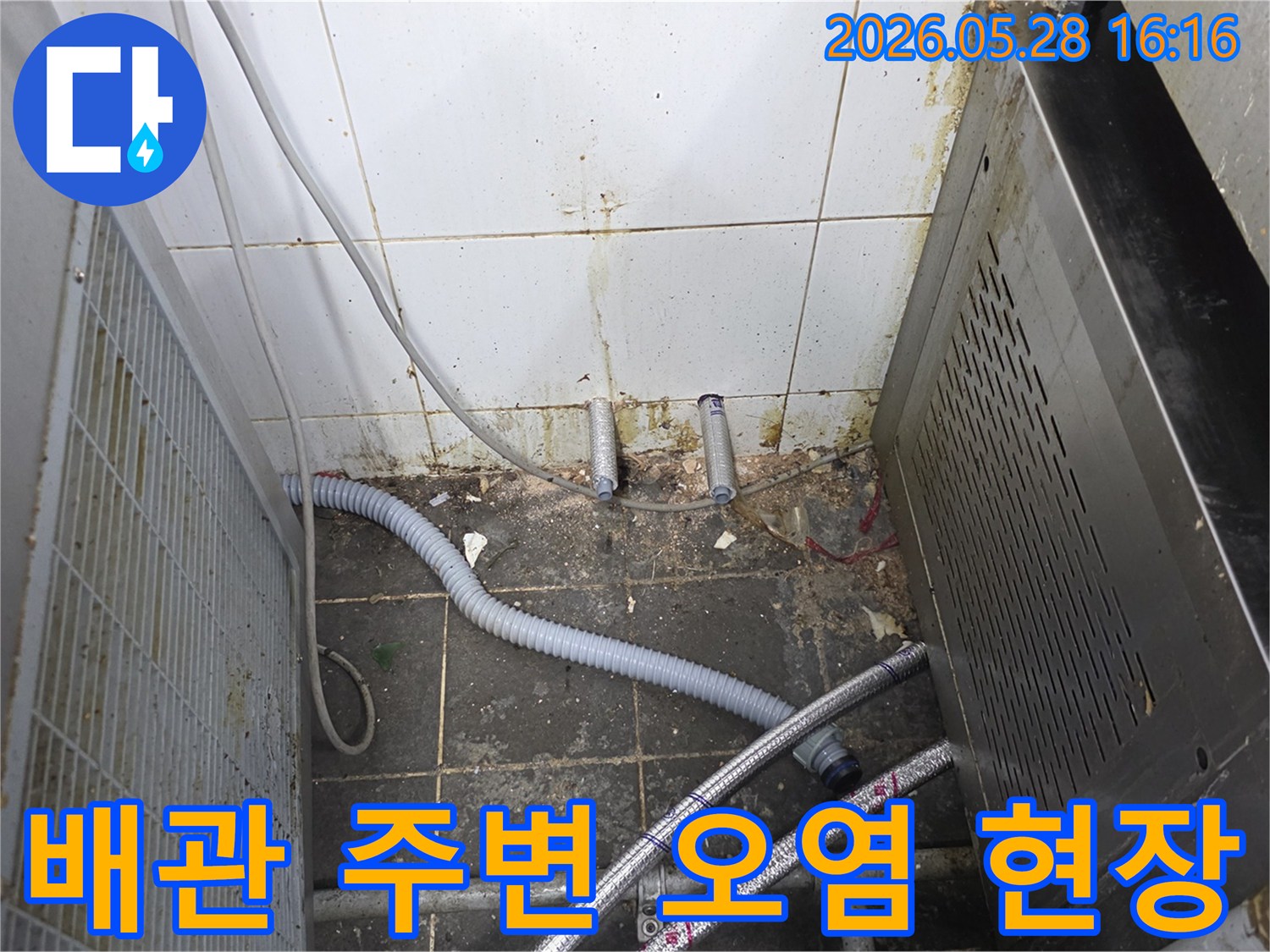 누수로 인해-지저분해진 배관 주변과-벽면 타일의-오염 상태를-보여주는 사진
