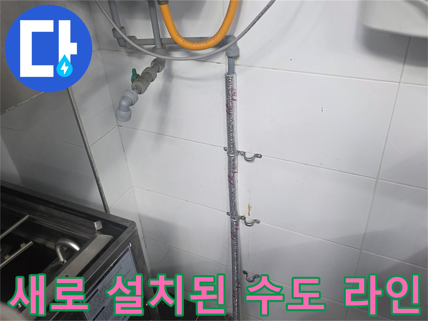 벽면 타일에 고정된 금속 배관과 연결 부품들