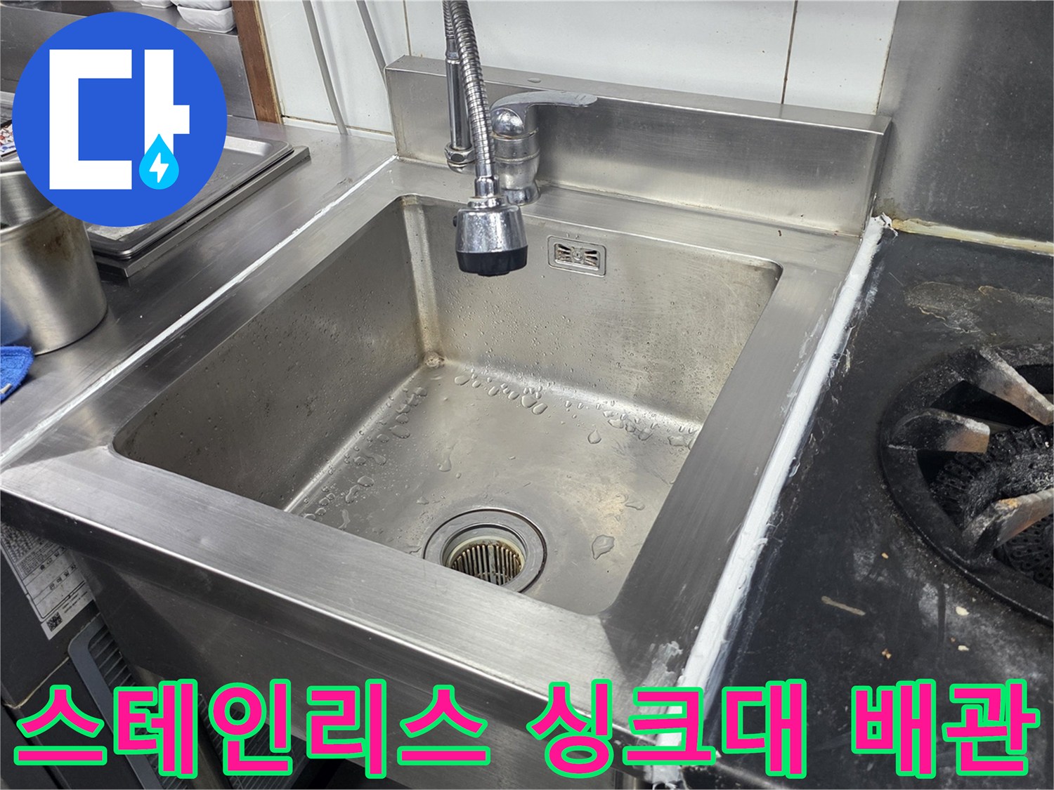 식당 주방의 스테인리스 싱크대와 수전 연결 부위 모습