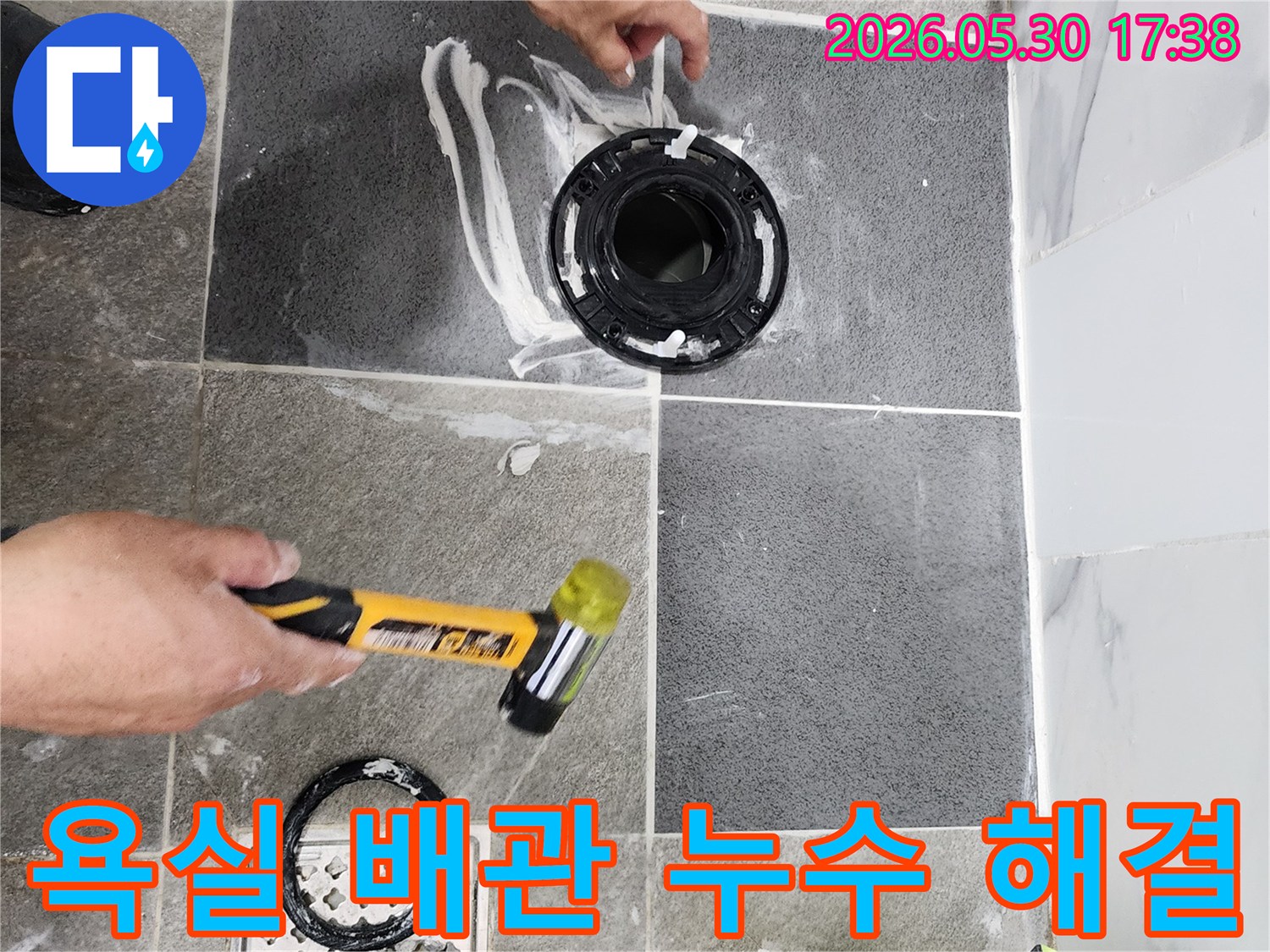 전문가가 욕실 바닥의-배관 연결 부위를-정밀하게 점검하고-누수 방지를 위한-보수 작업을 진행하고 있습니다.
