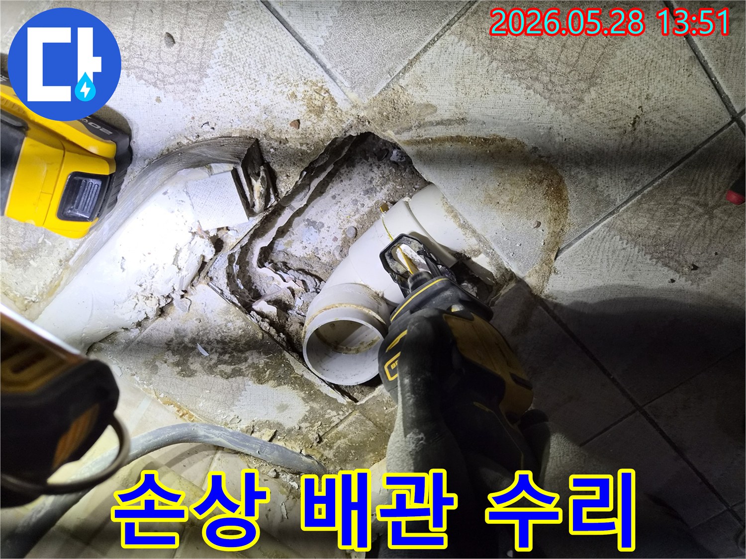 배관 파손으로 인한 누수 문제를 해결하고자-숙련된 기술자가-전동 공구를 사용하여-손상된 배관을 정밀하게 제거하고 있습니다.