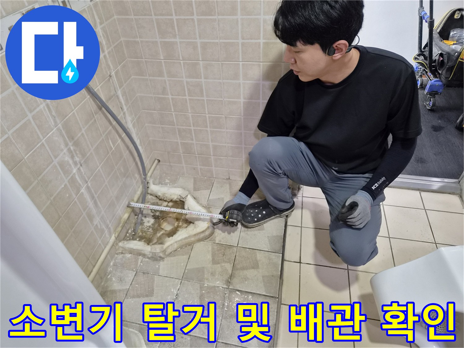 소변기 아래쪽 노출된 배관의 누수 여부를 점검하고 있습니다.