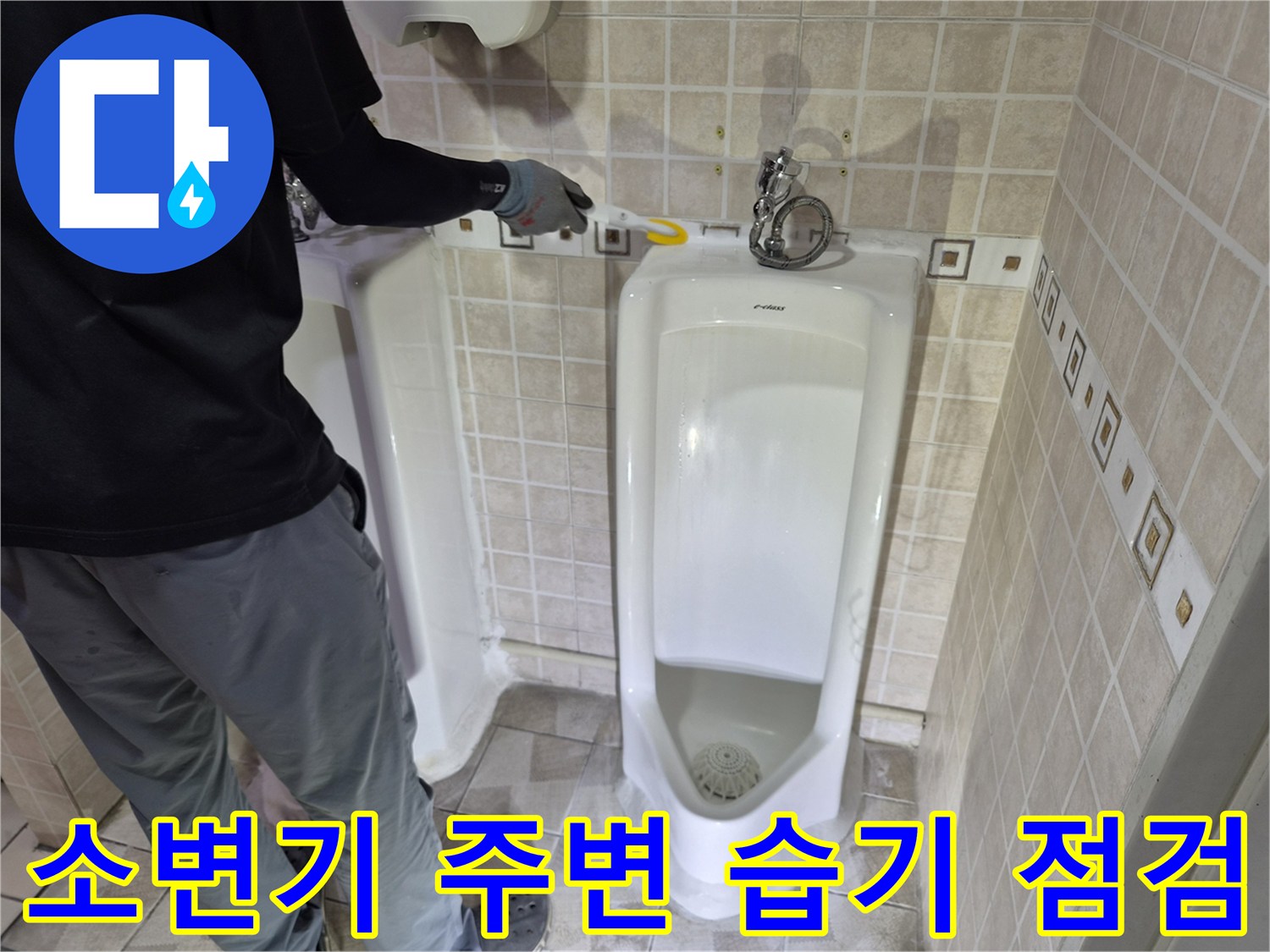 소변기 하단과 벽면 타일 경계의 물샘 증상을 촬영한 사진입니다.