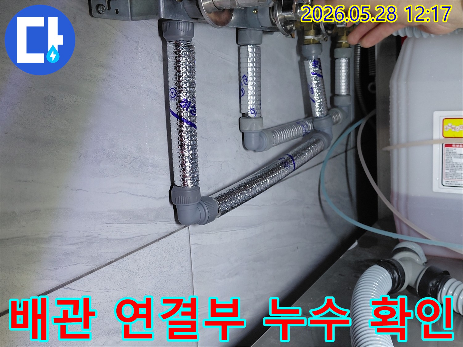 배관의 여러 연결 지점에서-누수 흔적을 찾아내기 위해-전문가가 직접 손으로 확인하는 모습