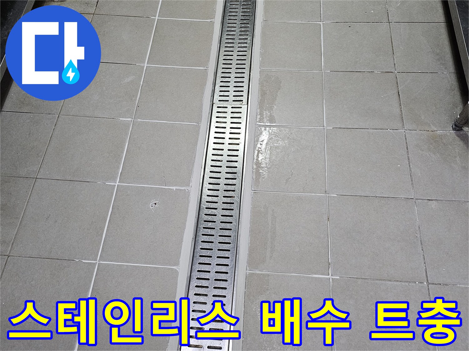금속 재질의 긴 배수 트렌치와 타일 마감 부위