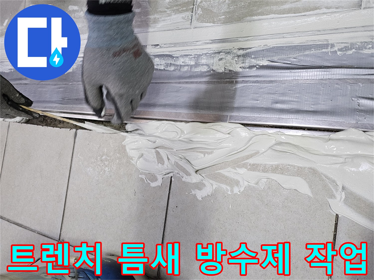 배수 트렌치 프레임 가장자리에 흰색 방수재를 도포하는 모습 - 누수 차단 공사