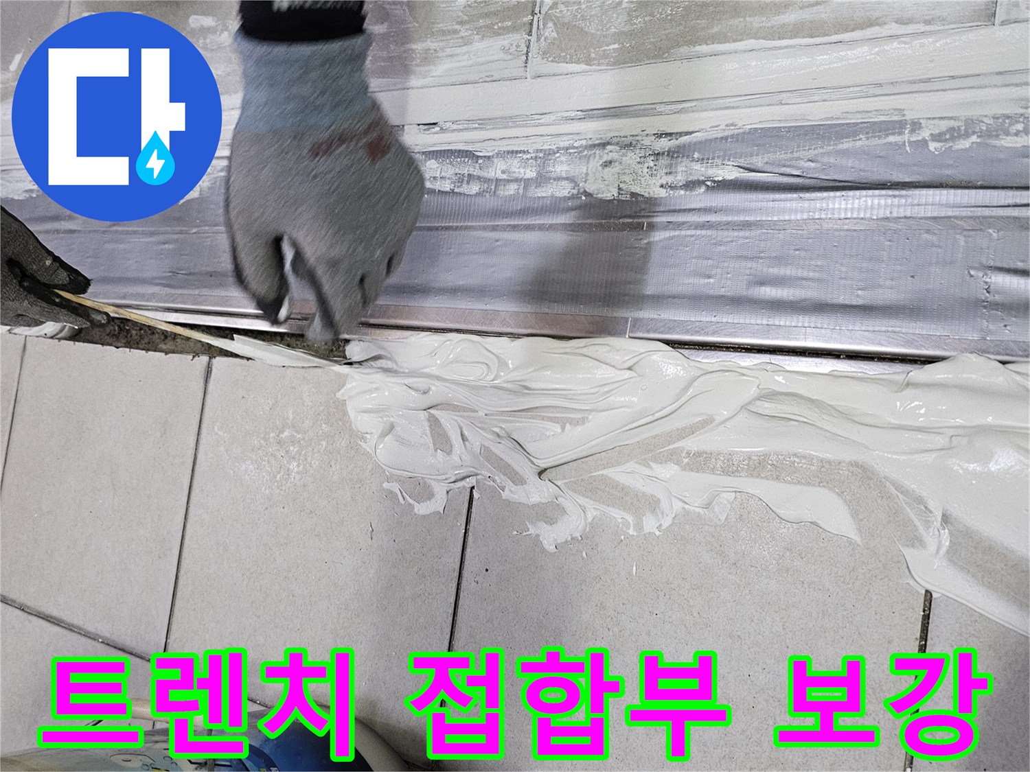 장갑을 낀 작업자가-배수 트렌치 틈새에 방수재를 채워 넣는 모습