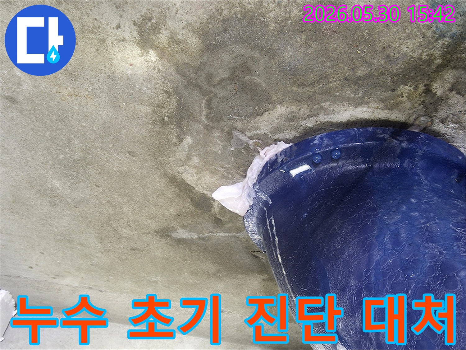 천장에서 물이 떨어지는 현장에서-초기 진단을 위해-파란색 양동이를 설치하여-물을 받아내는 모습입니다.