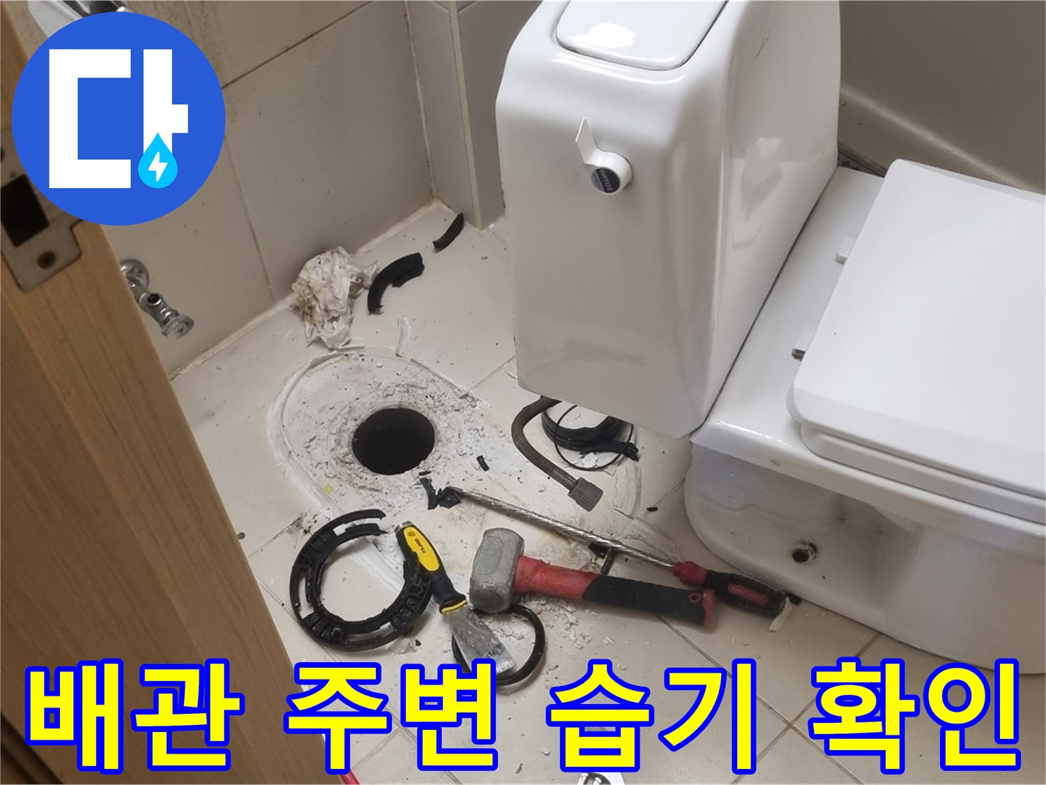 탈거된 변기와 함께 노출된 배관 입구의 상태를 찍은 사진입니다.
