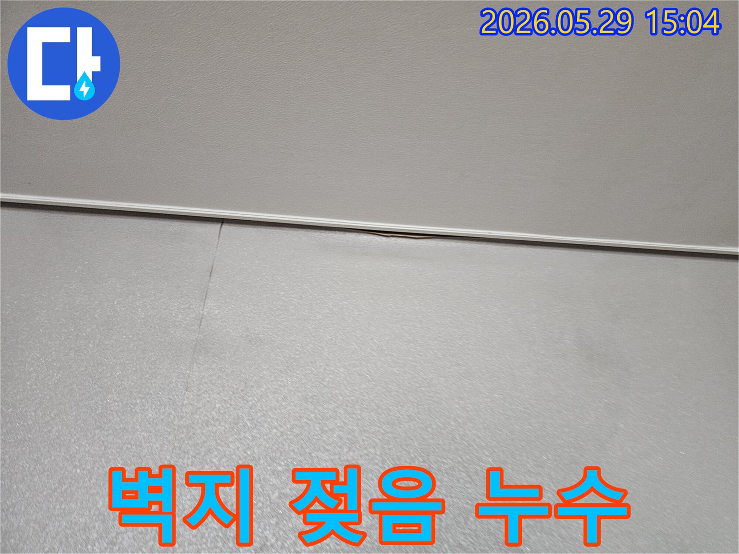 아파트 벽면 상단-모서리에 나타난-벽지 젖음 현상과-미세한 균열로-누수가 의심되는-초기 상황을 보여주는 이미지