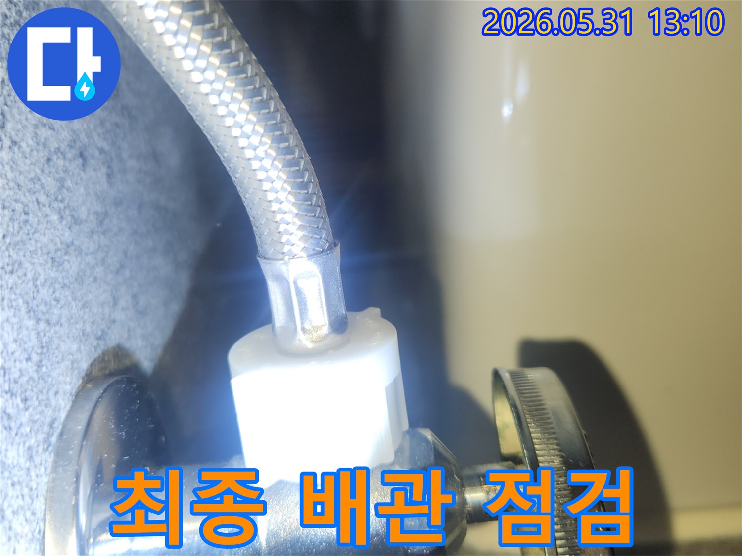 누수 수리 작업 후-수도 배관의 연결 상태를-최종적으로 점검하여-물샘이 없는지 확인하는 장면입니다.