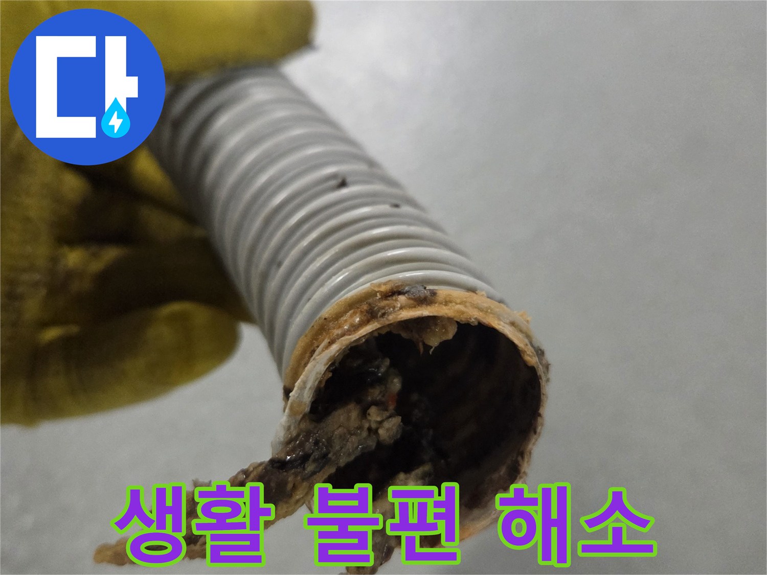 노란 장갑을 낀 작업자의 손이-오염된 배수관을 들고-문제 해결을 준비하고 있습니다.